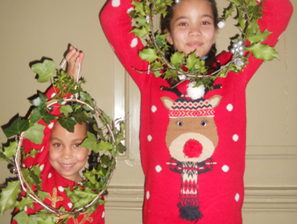 Children holding up Christmas wreaths