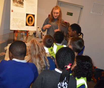 Volunteer showing children the bones in the basement