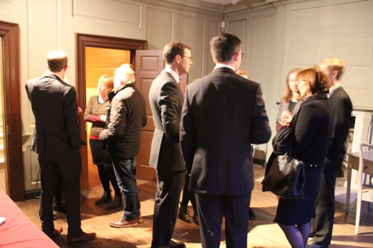 People standing and chatting in Franklin's parlour