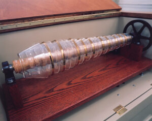 Glass armonica, a musical instrument. Glass bowls of ascending sizes are stacked on a cork spindle with a wheel at the end to turn the bowls and make a noise.
