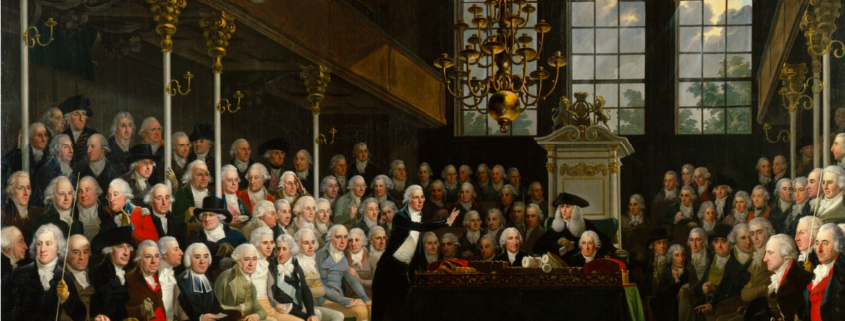 Painting of William Pitt addressing the House of Commons on the outbreak of war with Austria in 1793. He stands in the centre speaking to a crowded room of richly dressed white men in Georgian white powdered wigs. The room is expensively decorated with gold columns and chandelier.