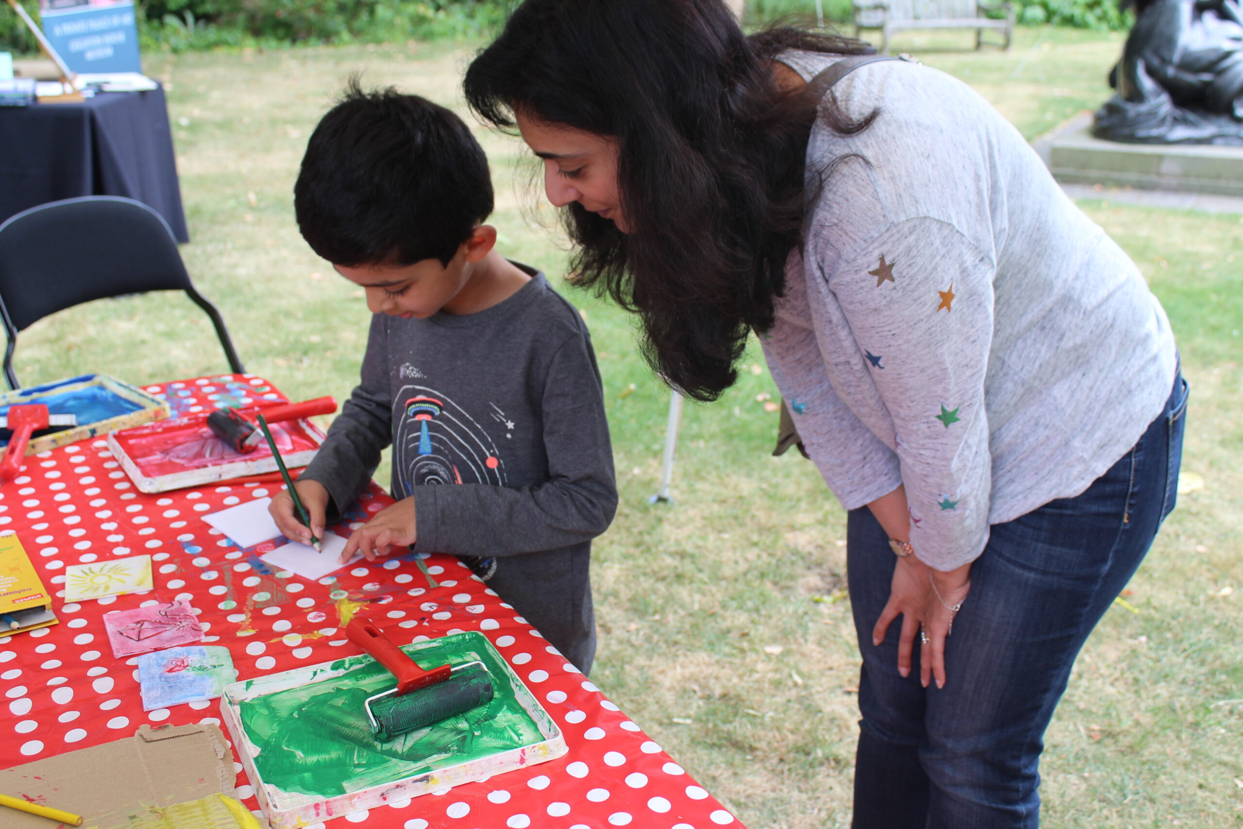 A young boy with his mother completing a lino print